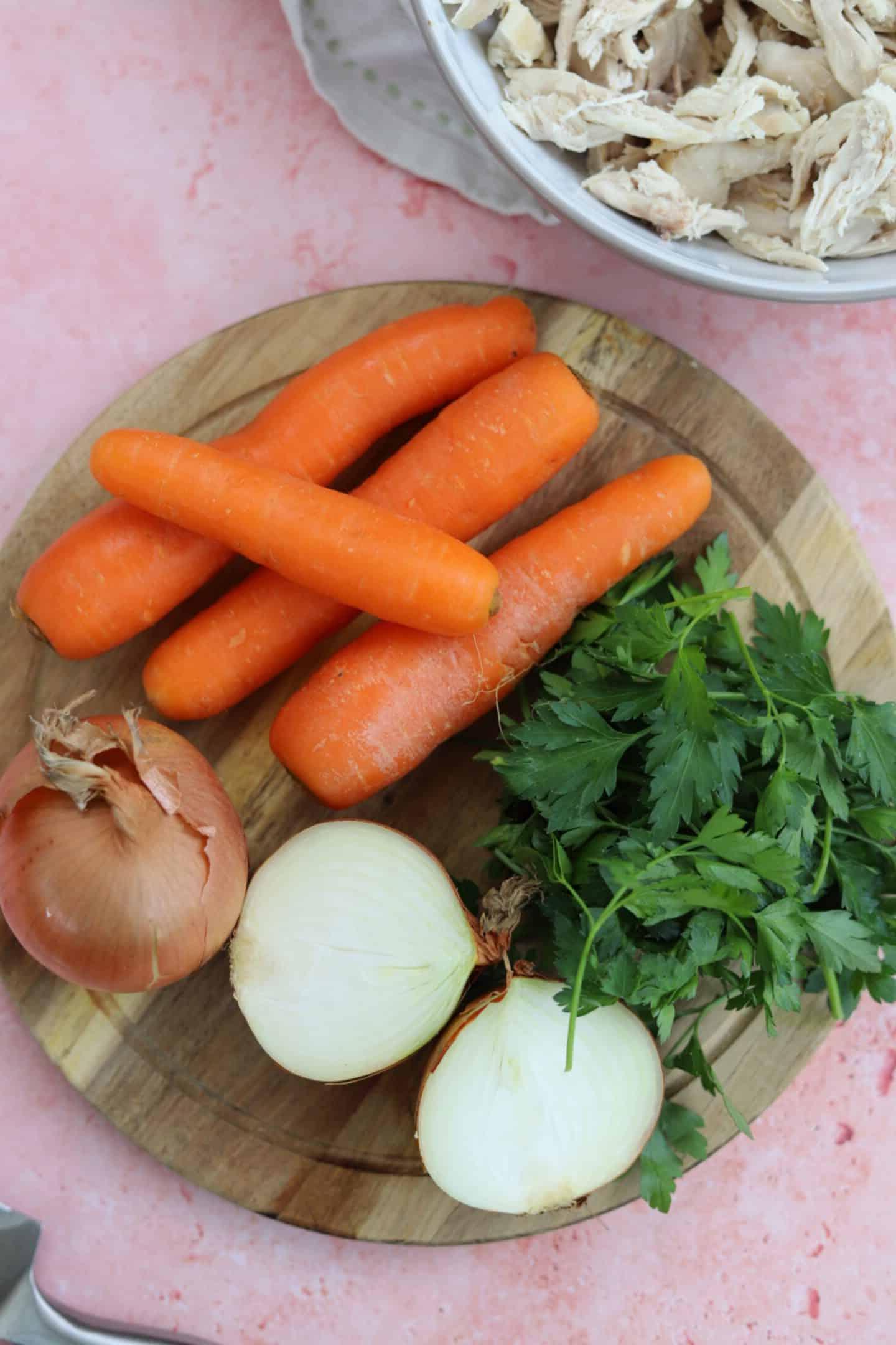 Brodo di Pollo Senza Glutine 4 Verdure per brodo di pollo senza glutine - carote, cipolla e prezzemolo su tagliere di legno