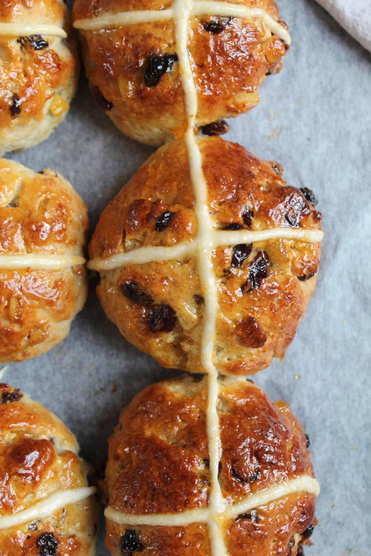 Primo piano di Hot Cross Buns senza glutine, che mostra la croce e la glassa lucida.