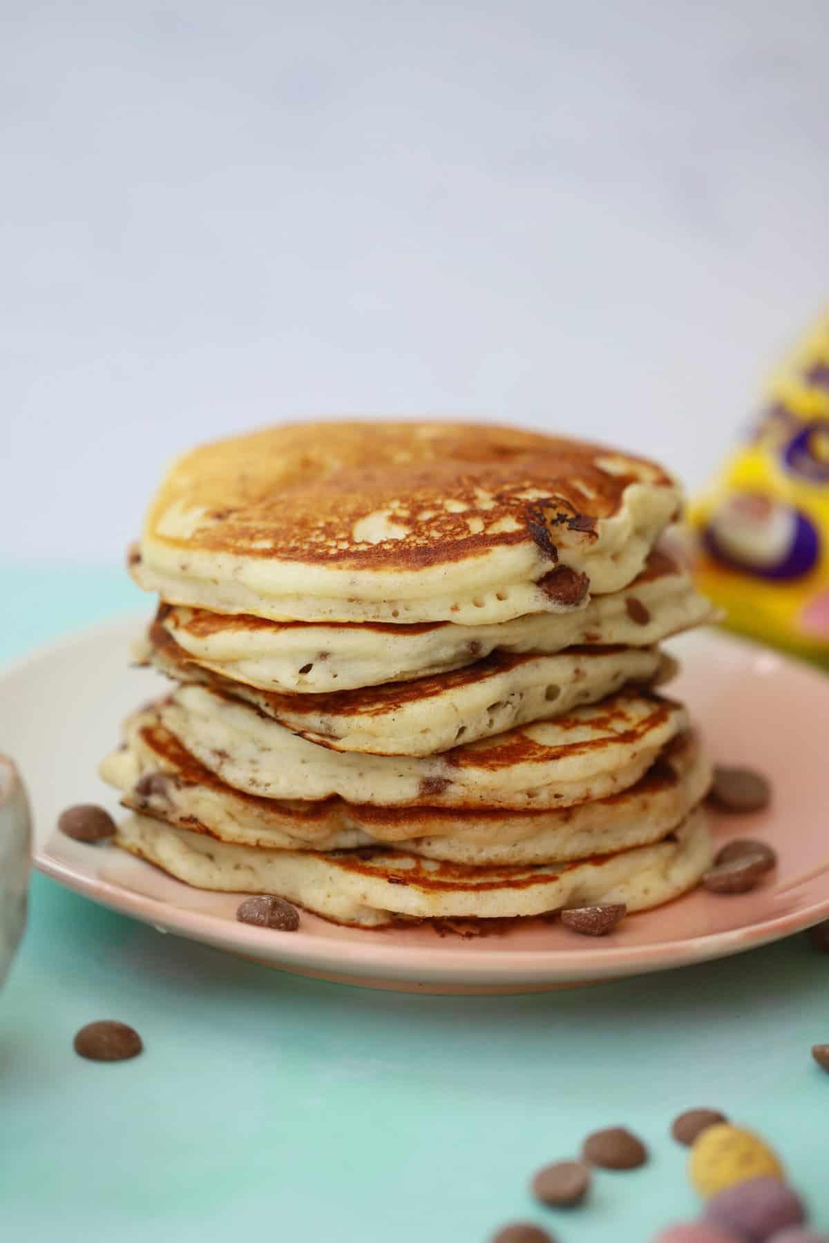 Mini Pancakes all'Uovo Senza Glutine 8 Una pila di pancakes con mini uova di cioccolato su un piatto pronta per essere guarnita.