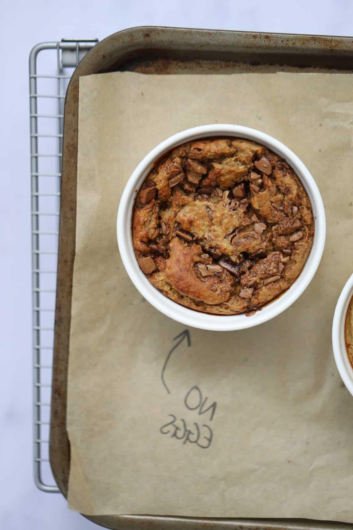 Avena al Forno 9 Una piccola ciotola di avena al forno su una teglia da forno etichettate 'senza uova'.