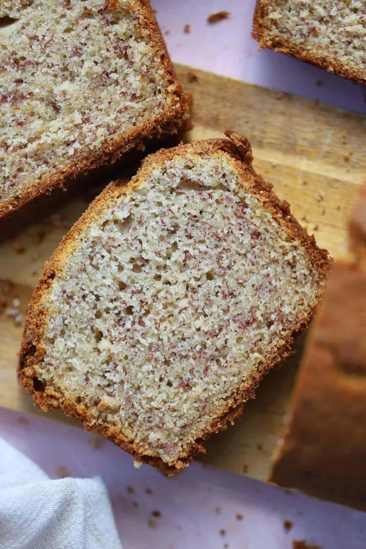 Banana Bread Senza Glutine 9 Primo piano di fette di banana bread senza glutine su un tagliere.