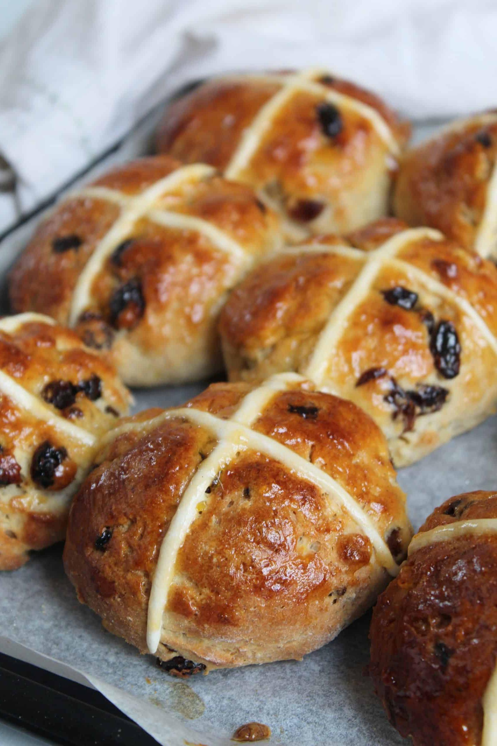 Un vassoio di Hot Cross Buns senza glutine con glassa lucida.