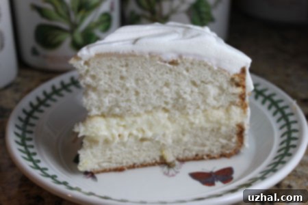 A slice of lemon cream cake on a plate, showcasing the creamy filling and light frosting.