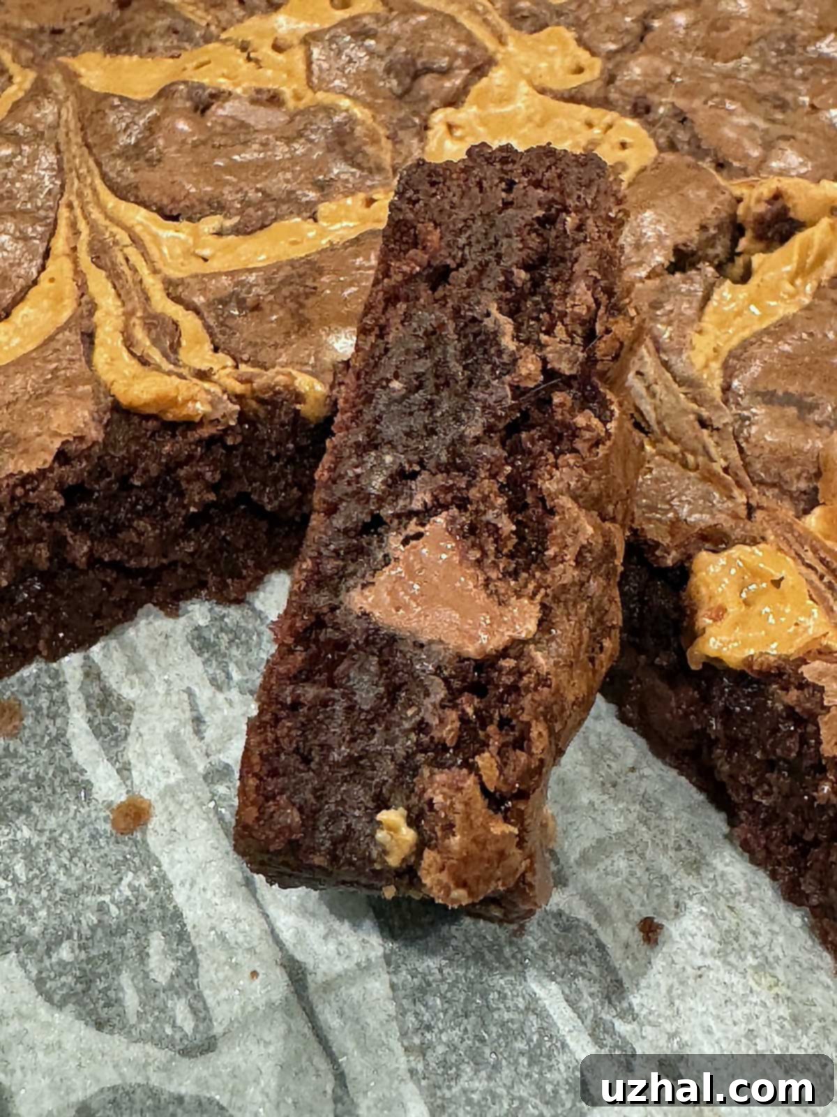 Slice of milk chocolate brownie with a big milk chocolate chip in the cross-section.