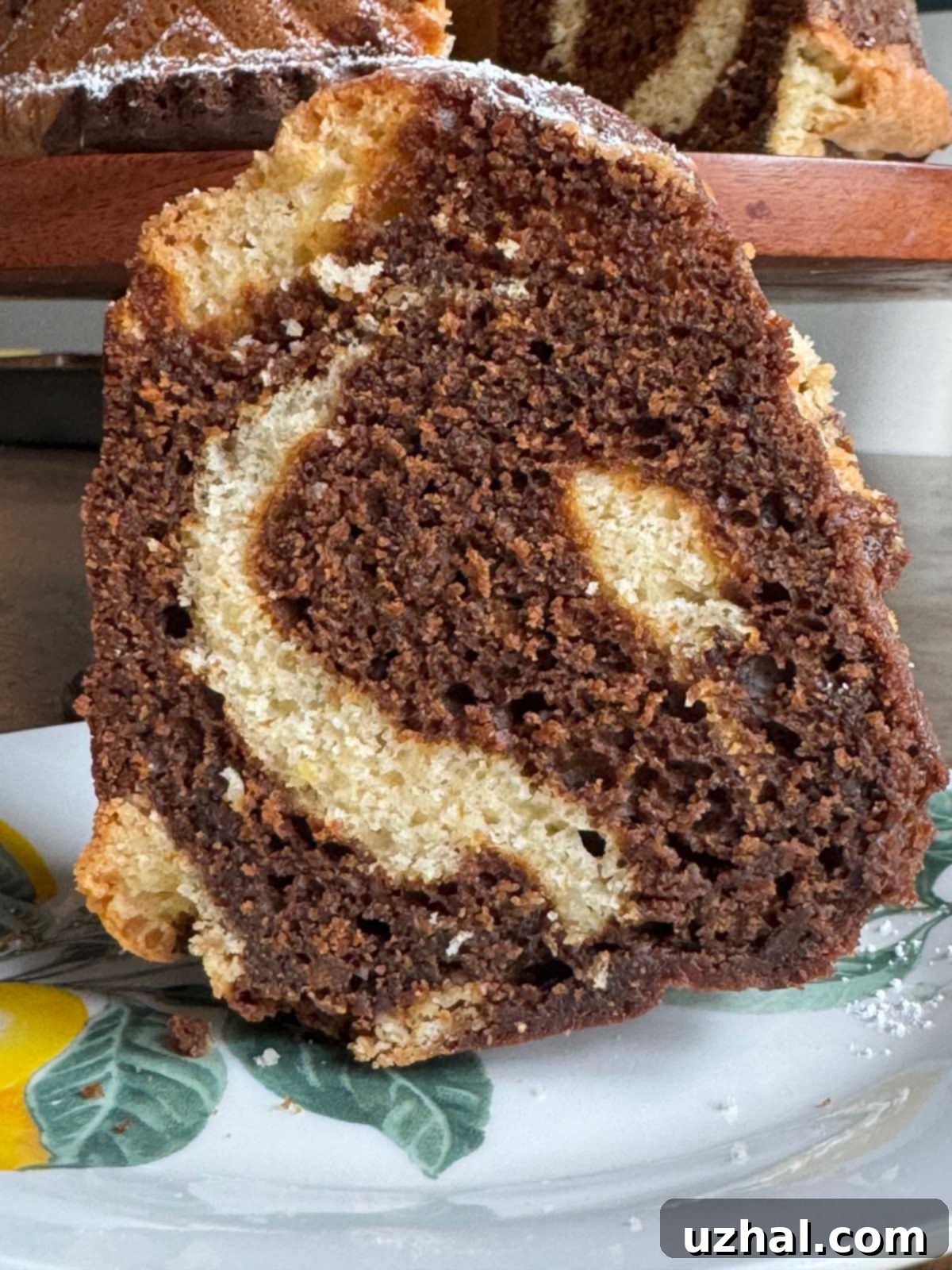 Slice of molasses and lemon cake on a plate, showcasing its beautiful marble pattern.