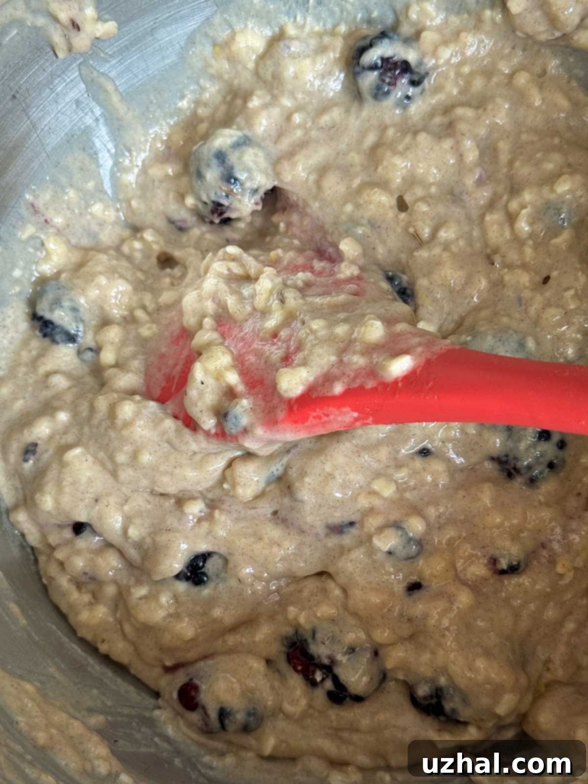 The 'ugly' quick bread batter, grey and lumpy with purple blackberry streaks, in a mixing bowl, ready for baking.
