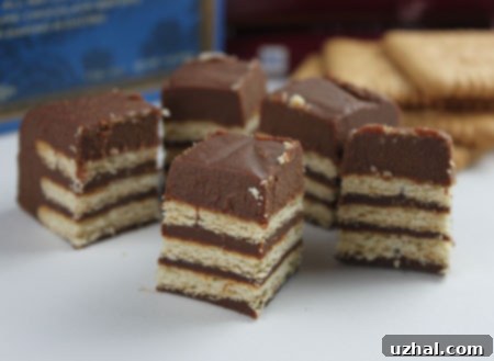 A sliced Danish Chocolate Biscuit Cake topped with whipped cream and chocolate shavings.