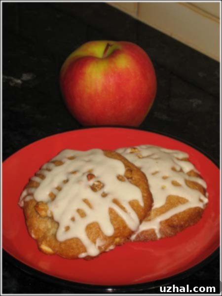 Cyndi's Spiced Apple Cookies with a generous layer of apple icing, arranged on a rustic plate.