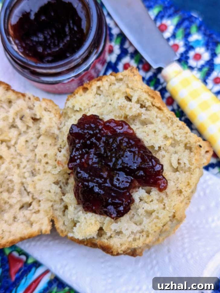 Cooked Oatmeal Muffin pictured on a plate, split, and with jelly, showcasing its fluffy texture.