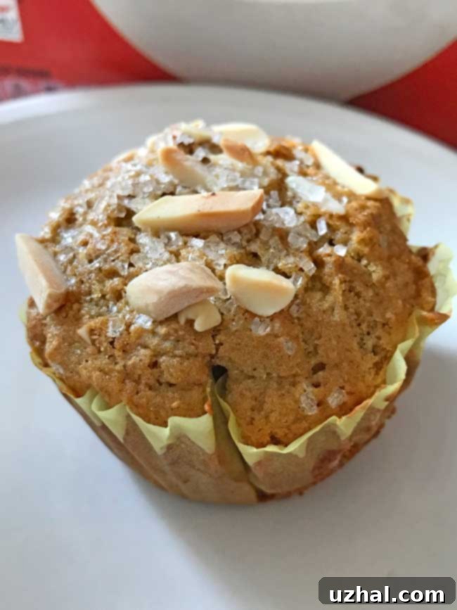 Freshly baked Maple Bran Muffins, topped with sliced almonds and coarse sugar, arranged on a cooling rack.