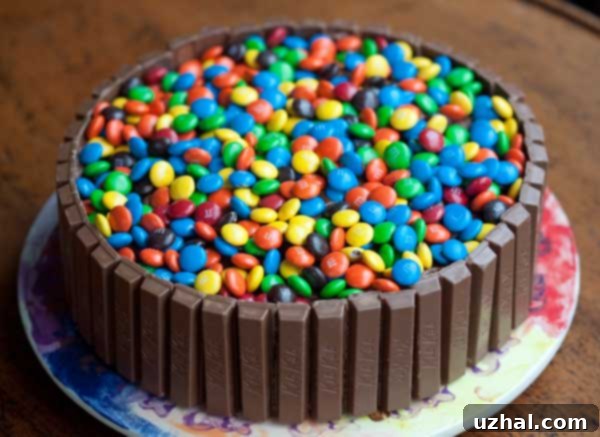 Delicious and decorative Kit Kat Cake with colorful candies on top, ready for a celebration.