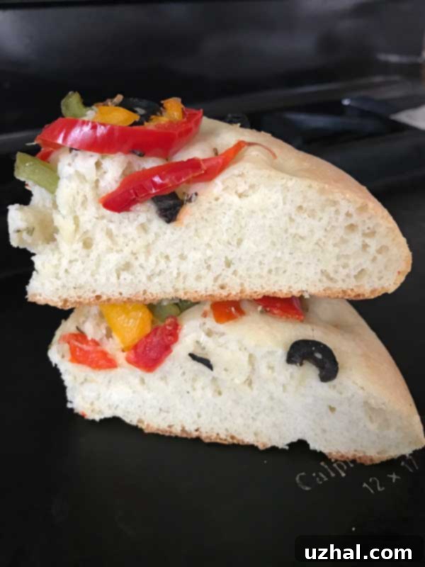 small batch focaccia loaf on a baking sheet, golden brown with dimples