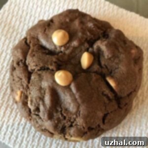 A freshly baked giant chocolate peanut butter chip Levain-style cookie on a cooling rack.