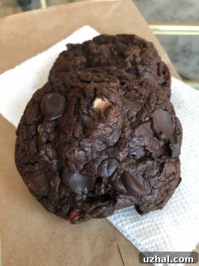 Close-up of baked Black Gold Cookies with visible chocolate chunks and nuts, highlighting their rich texture.