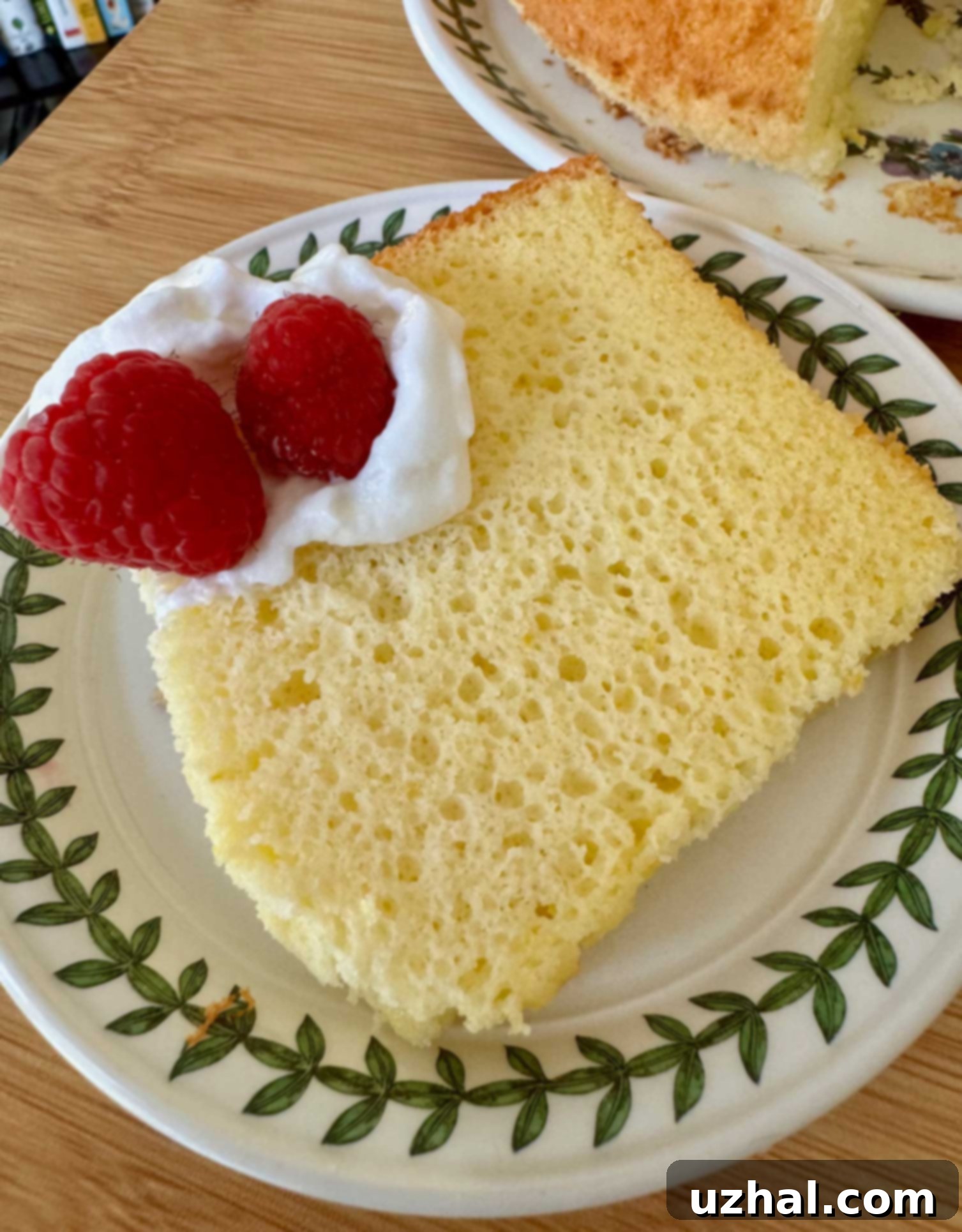 Close-up slice of Classic Orange Chiffon Cake showcasing its incredibly light, airy, and moist texture with visible orange zest flecks.