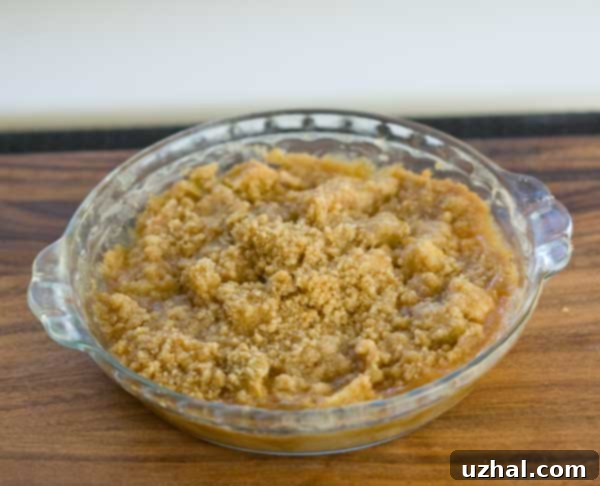 Close-up of a slice of Rosemary's Apple Crumb Pie, showing the apple filling and crumb topping