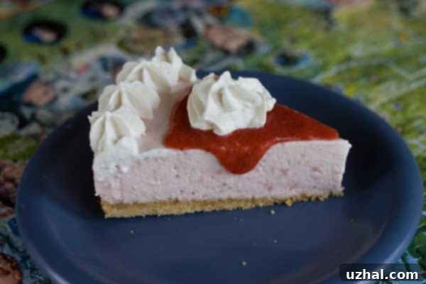 Strawberry Smoothie Cheesecake garnished with whipped cream and a whole strawberry