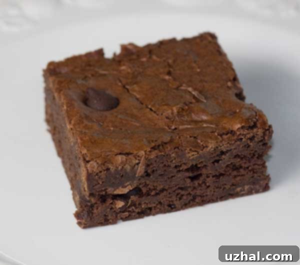 A square glass dish brownie on a white plate