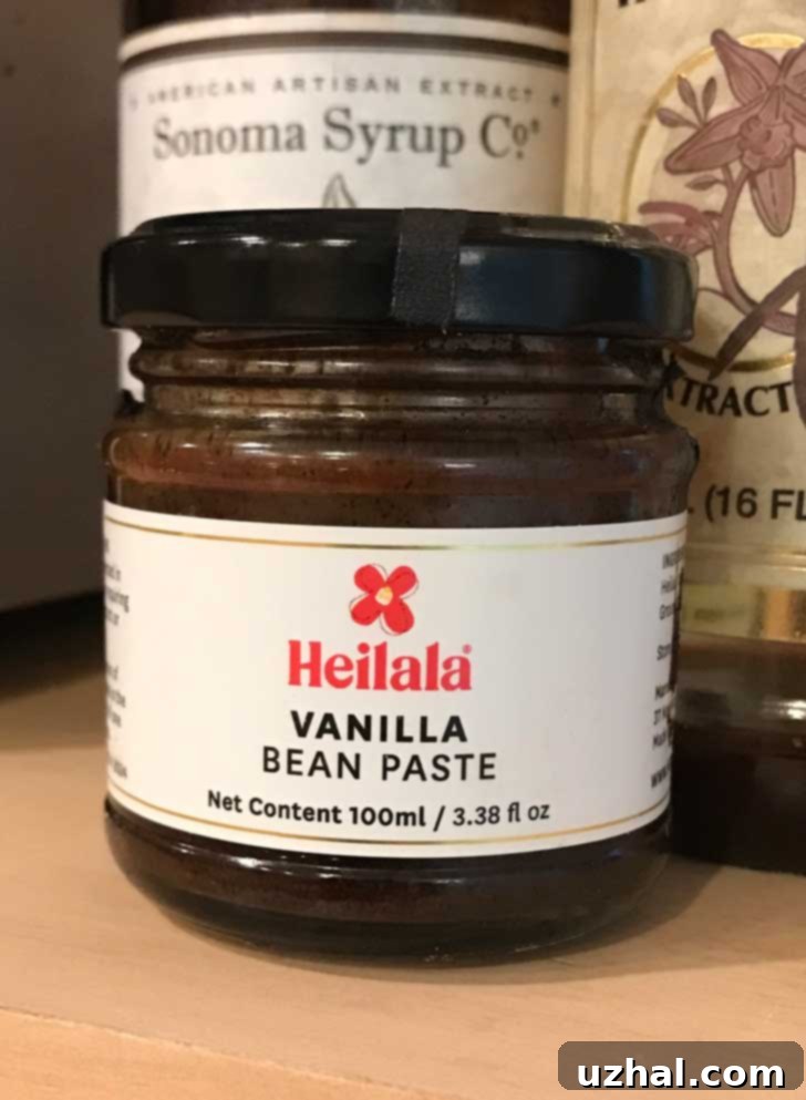 A jar of high-quality vanilla bean paste, showing its thick consistency and specks of vanilla bean