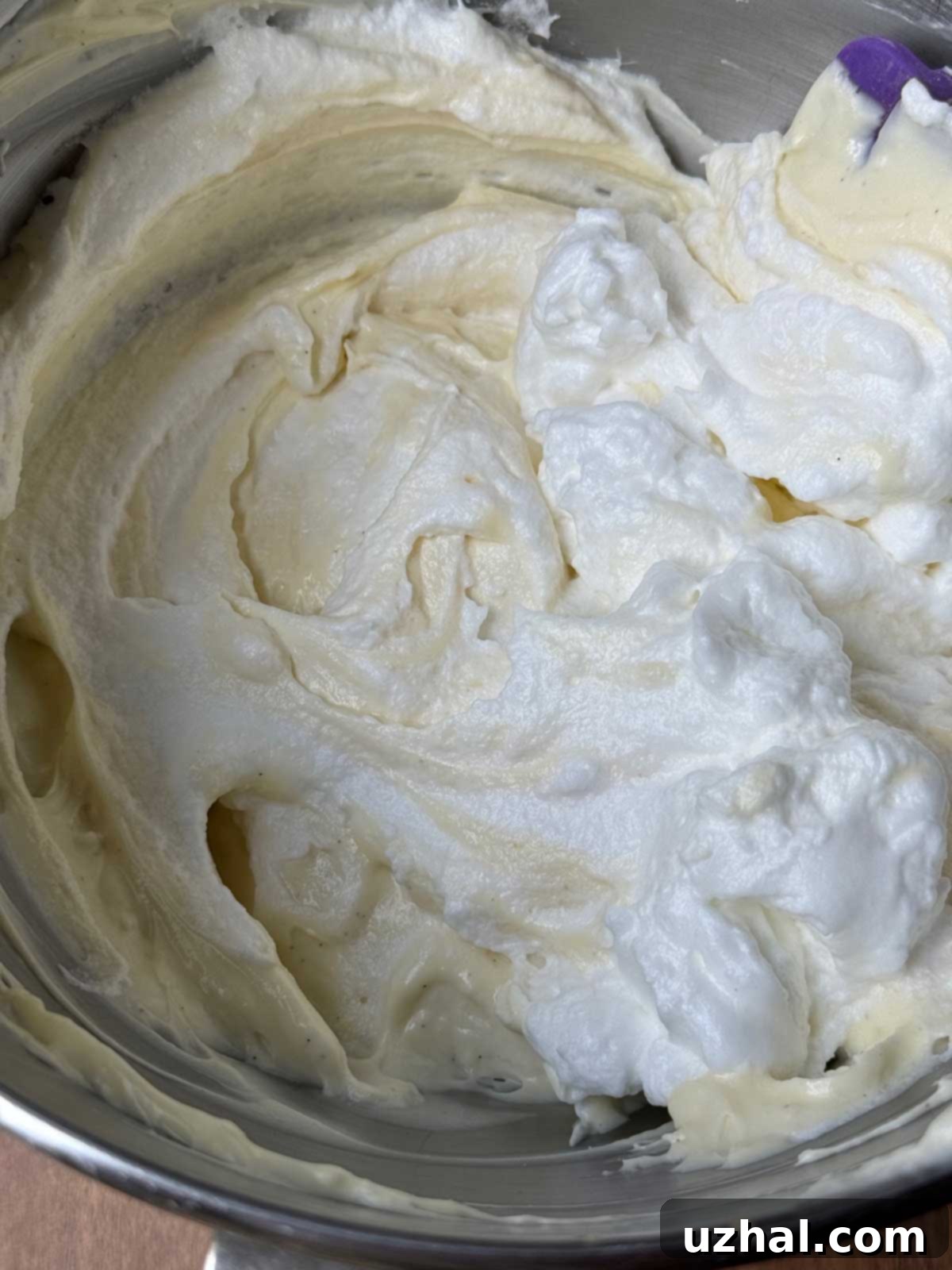 The creamy filling for an Oreo cheesecake, with fluffy whipped egg whites being gently folded in to create a light and airy texture.