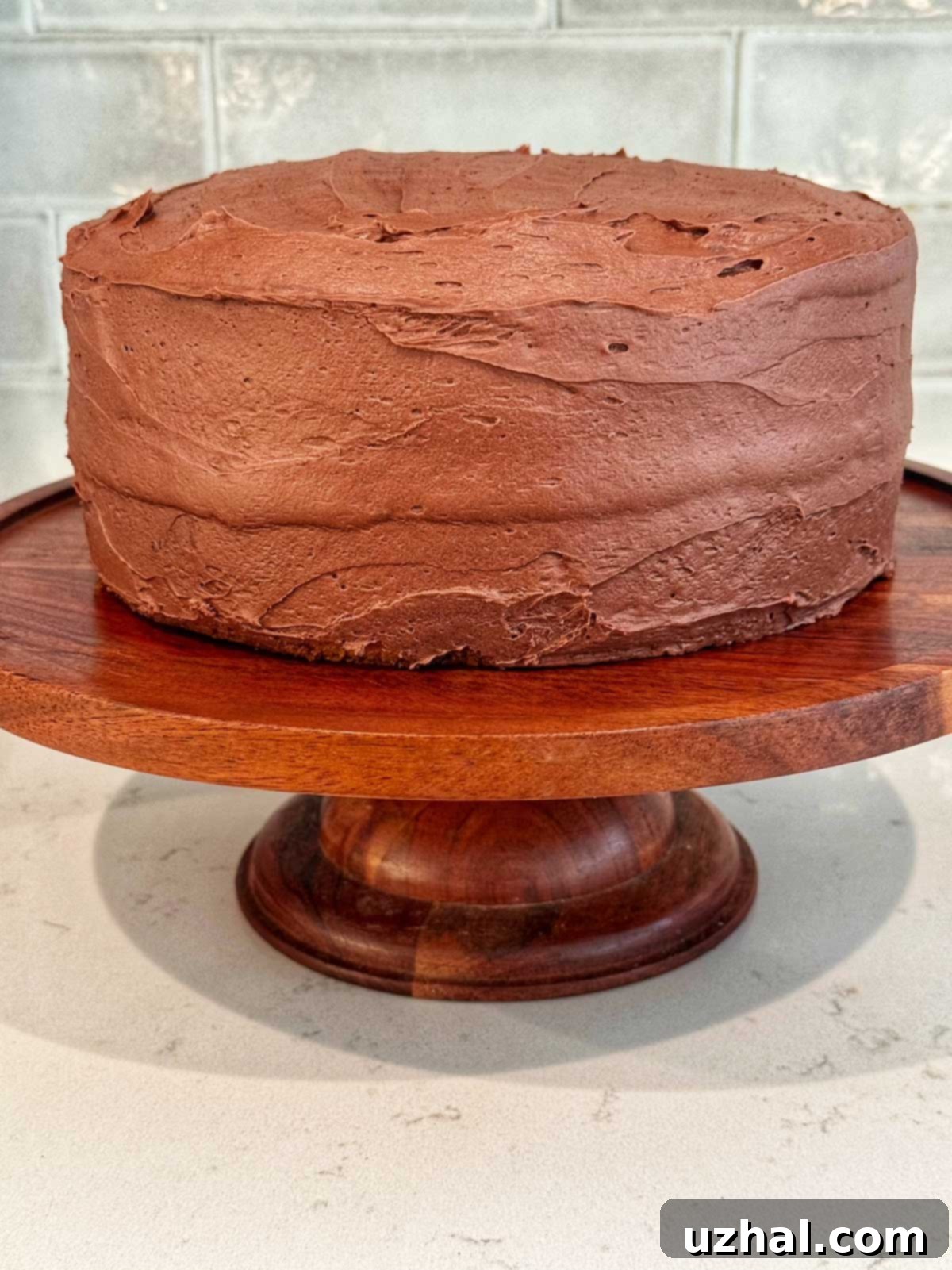A tall slice of yellow cake with chocolate frosting, demonstrating the high cake-to-frosting ratio.
