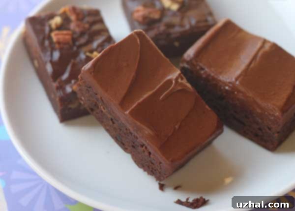 Perfectly sliced frosted fudge brownies on a cooling rack.