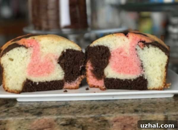 A beautifully sliced Loaf Pan Neapolitan Cake showing distinct vanilla, chocolate, and strawberry layers.
