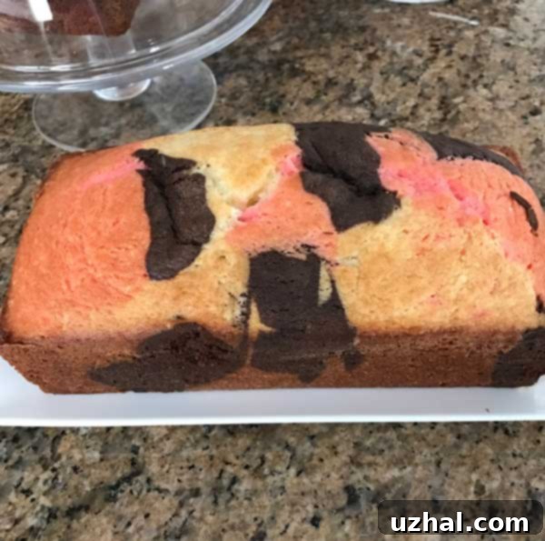 A top-down view of the baked Neapolitan cake, with visible swirls of vanilla, chocolate, and strawberry.