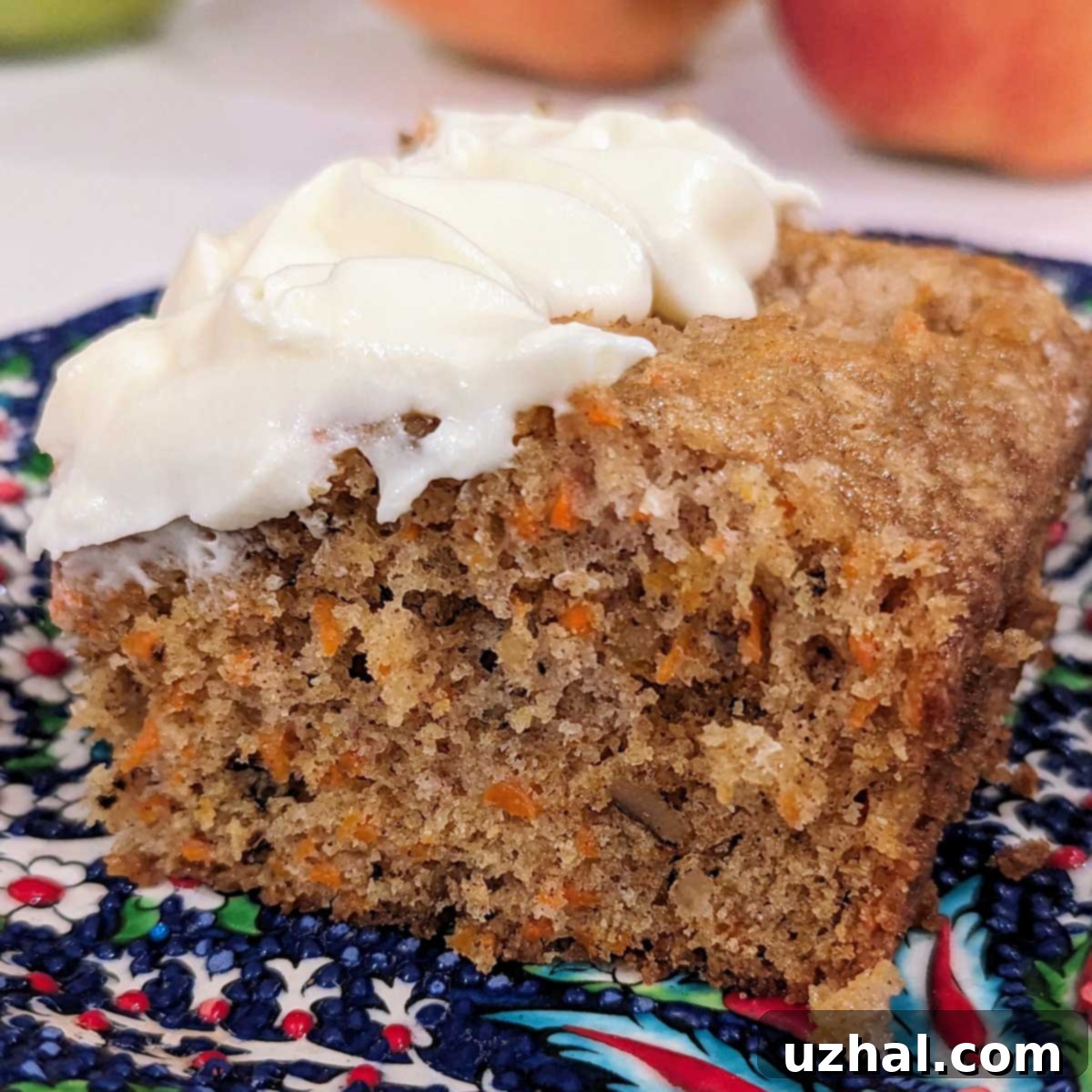 A perfectly baked, moist Sour Cream Carrot Cake with cream cheese frosting, garnished with nuts.