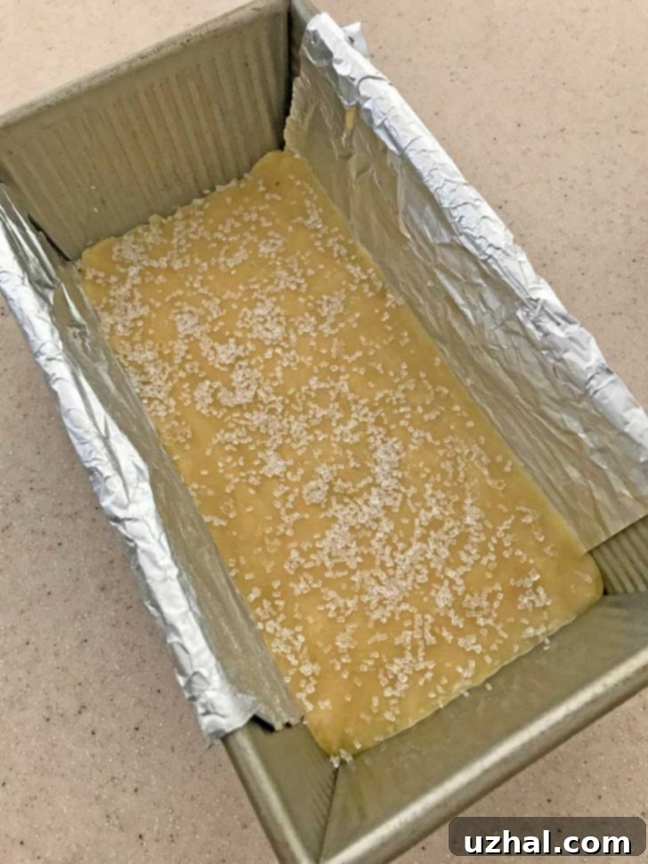 Scottish Shortbread dough pressed into an 8.5x4.5 inch loaf pan, ready for baking.