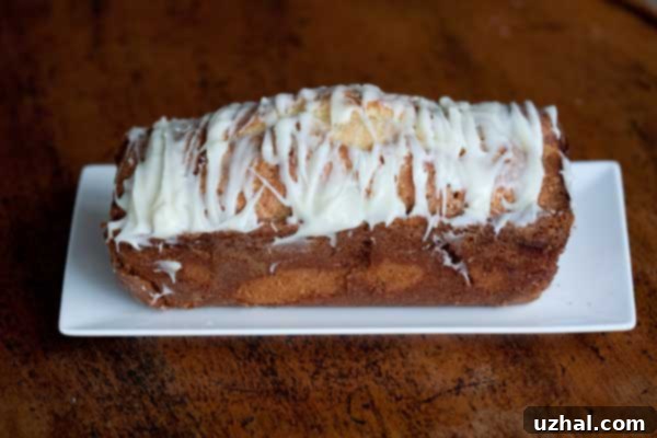 Cinnamon Roll Pound Cake with Cream Cheese Icing drizzled on top.