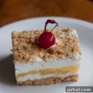 Finished Banana Split Cake ready for serving, garnished with nuts and cherries.