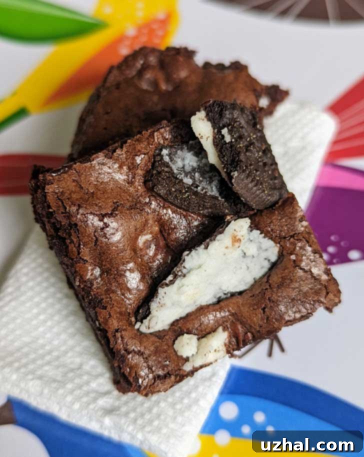 An 8-inch pan of gluten-free brownies generously topped with broken Gluten-Free Oreos, ready to be enjoyed
