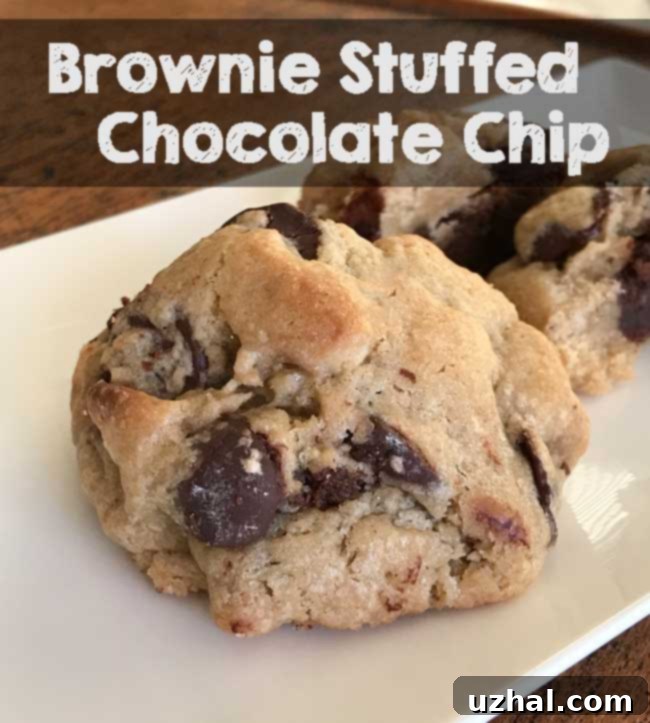 Delicious Brownie Stuffed Chocolate Chip Cookies stacked, showing the rich brownie filling within a golden cookie.