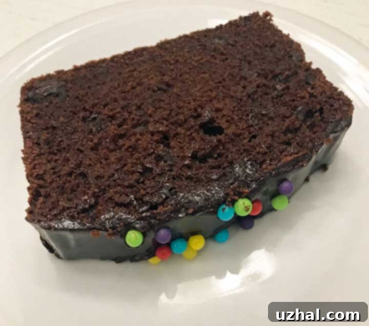 Close-up of the shiny chocolate glaze and colorful sprinkles on the loaf cake