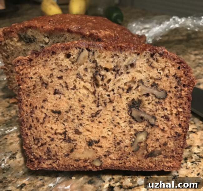 Freshly baked loaf of two-banana banana bread cooling on a wire rack, showcasing its golden-brown crust.