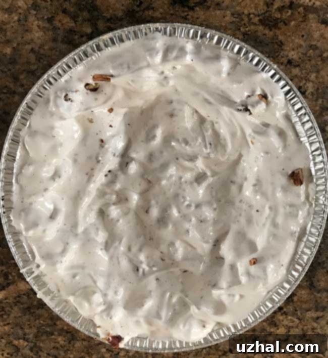 Unbaked meringue pie crust in a disposable aluminum pie pan, ready for the oven.