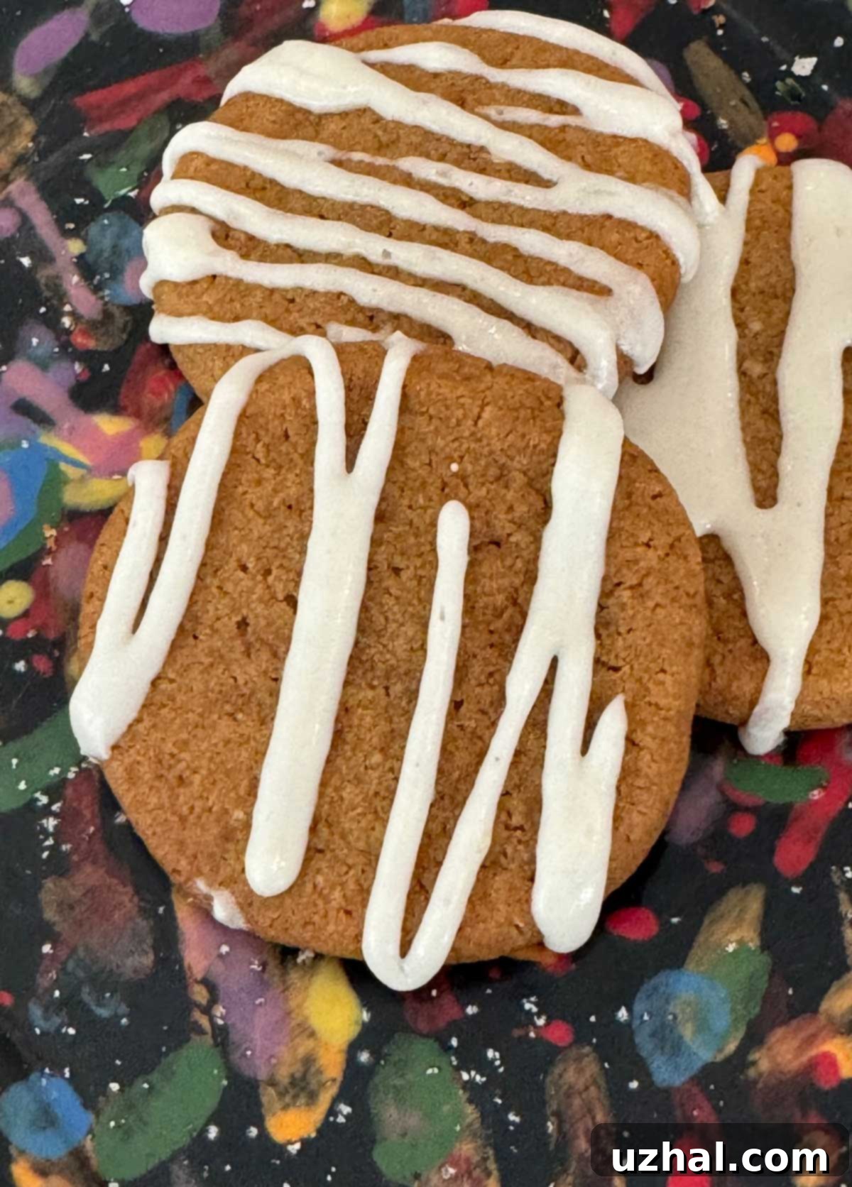 Molasses cookies with a beautifully opaque white frosting drizzled over them.