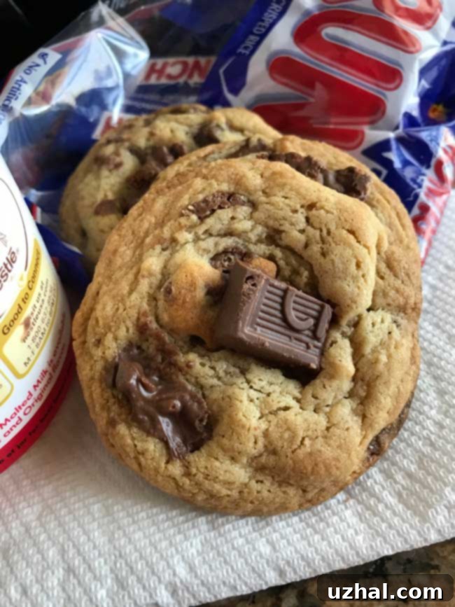 Malted Milk Chocolate Chunk Cookies - A stack of perfectly baked, chewy cookies with melted milk chocolate chunks visible, resting on a cooling rack.
