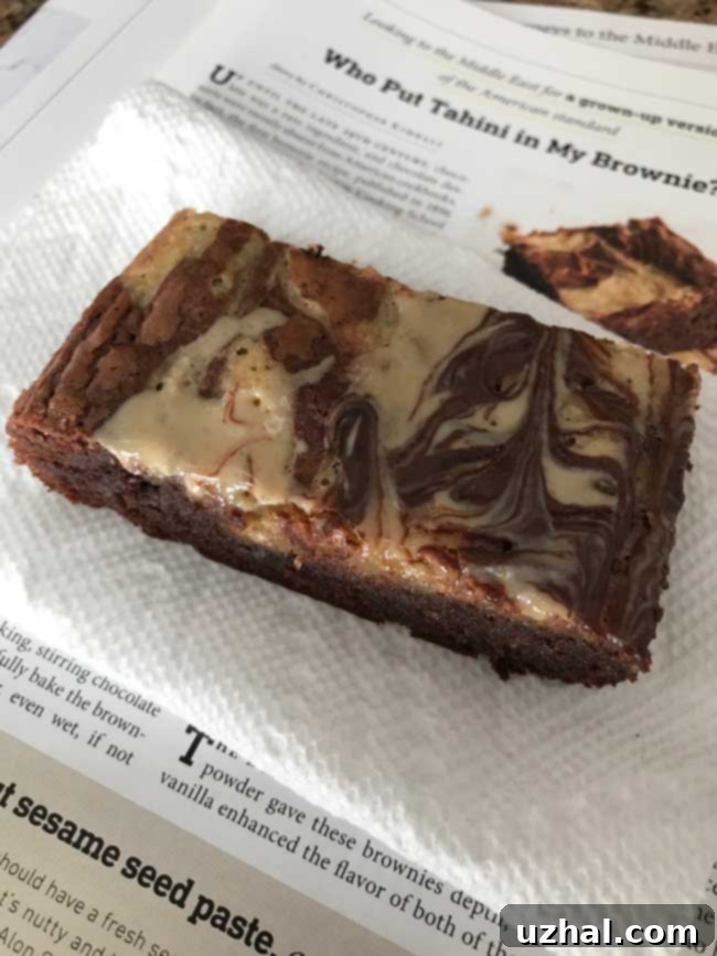 A perfectly sliced Tahini Brownie revealing its fudgy interior and distinct tahini swirl.