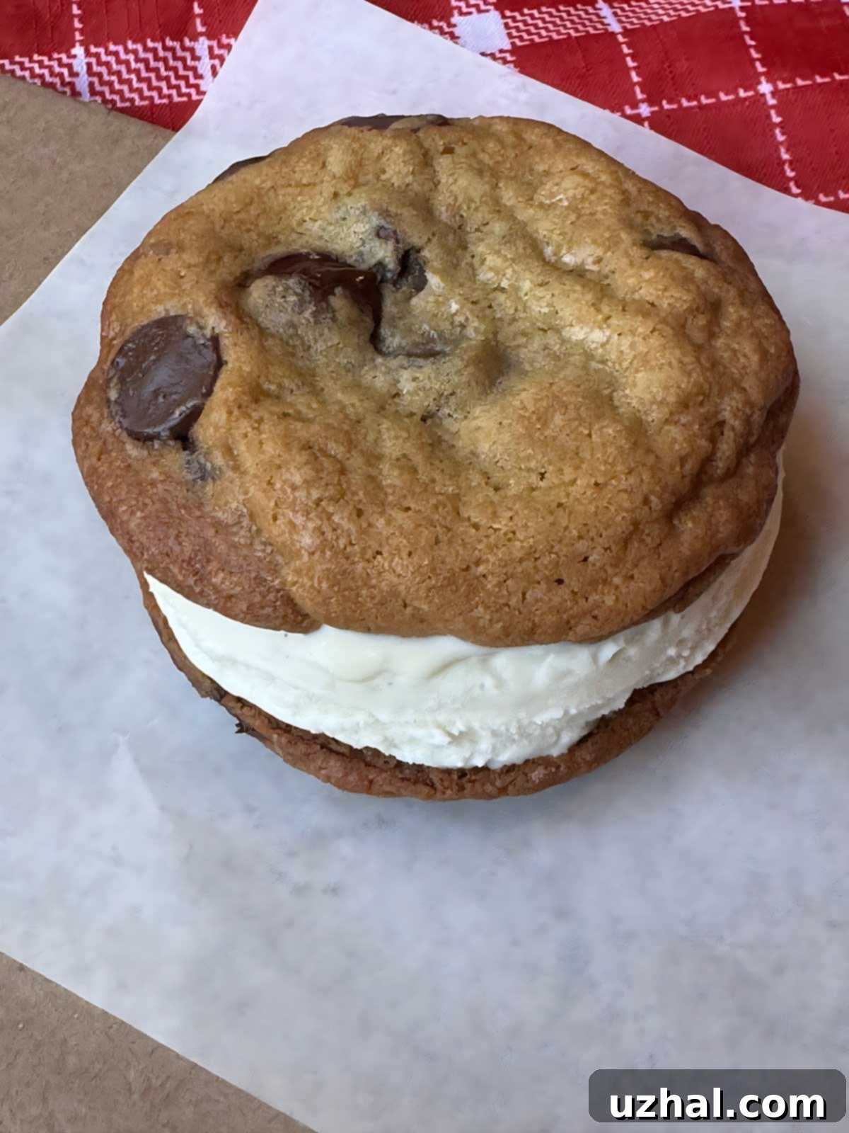 Delicious cream cheese chocolate chunk cookies with ice cream sandwiched between them, forming giant chocolate chunk ice cream sandwiches.