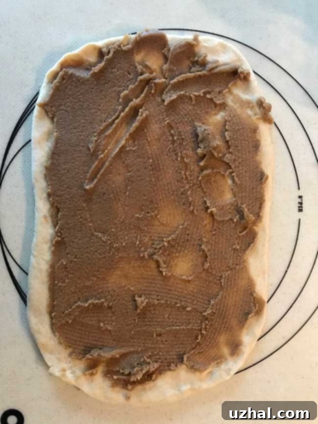Dough for cinnamon rolls with brown sugar and butter spread on top.