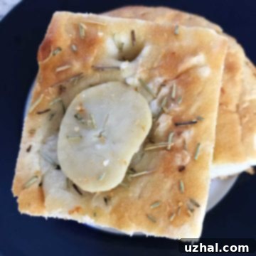 Potato Focaccia - A close-up of a freshly baked potato focaccia, golden brown with rosemary and sea salt.
