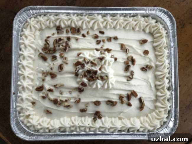 Delicious Buttermilk Glazed Carrot Cake baked in a disposable pan, topped with a generous layer of fluffy, perfectly balanced cream cheese frosting.