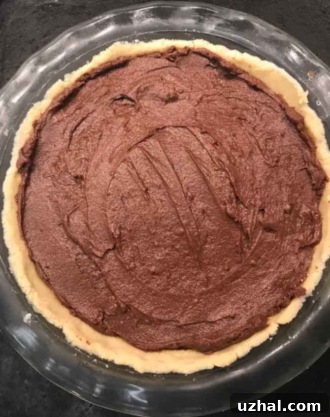 Close-up of the almond flour crust pressed into a pie dish, ready to chill.