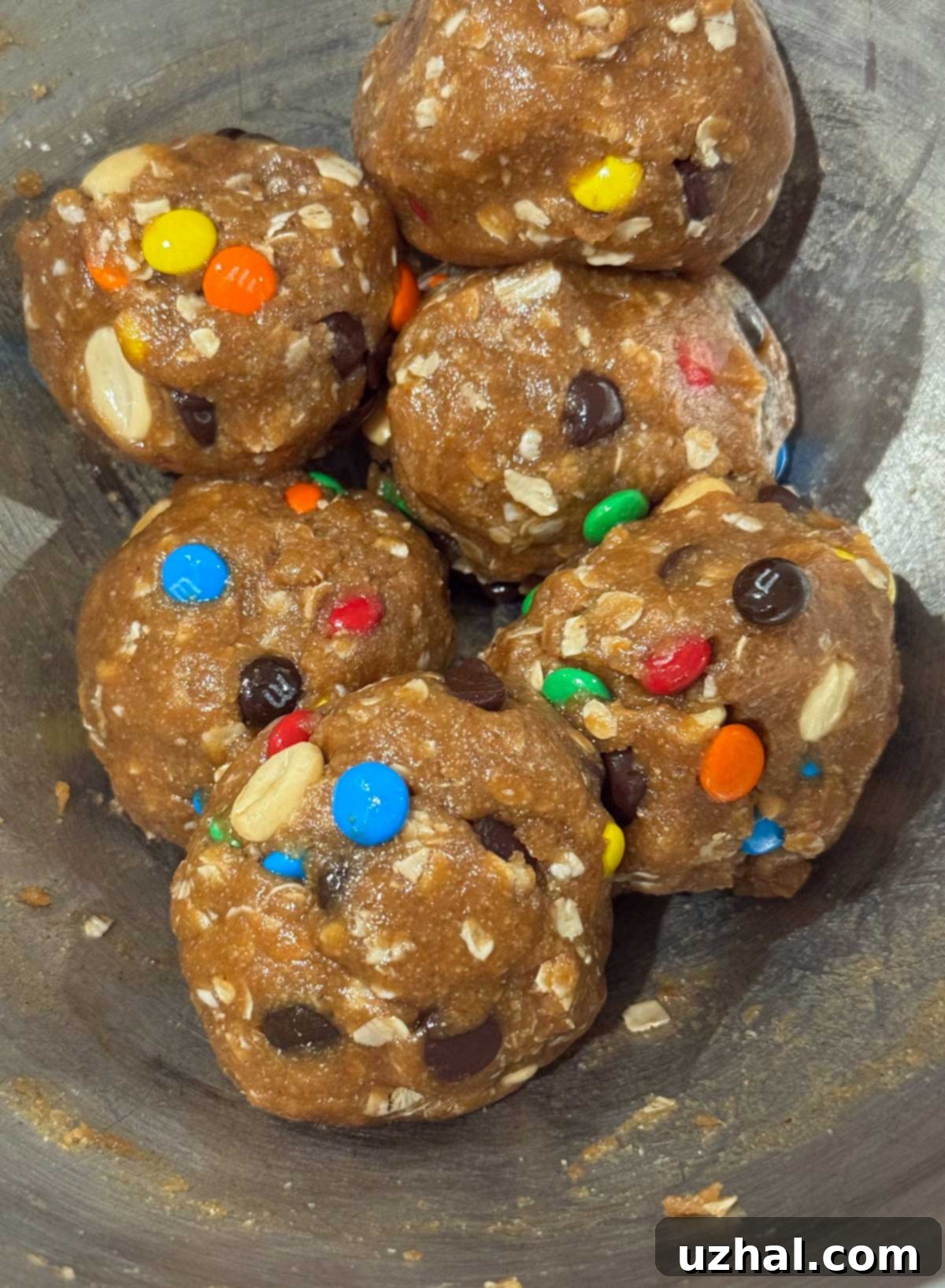 A batch of perfect, gluten-free Oat Flour Monster Cookies cooling on a wire rack.
