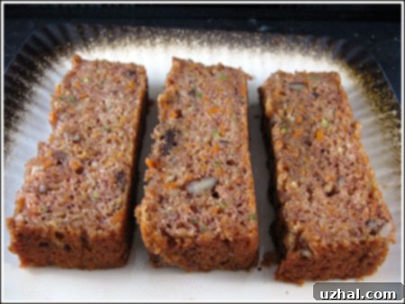 A delicious slice of Garden Harvest Cake, showcasing its moist crumb and visible pieces of fruit and nuts.