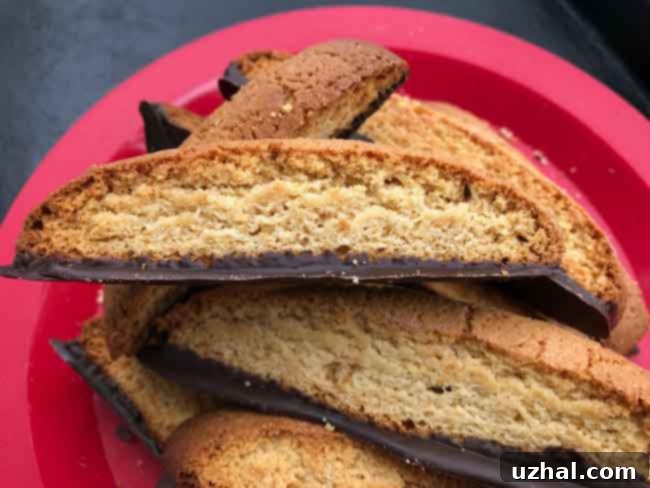 Two perfectly baked Malted Milk Biscotti logs on parchment paper, displaying an ideal shape and golden color.