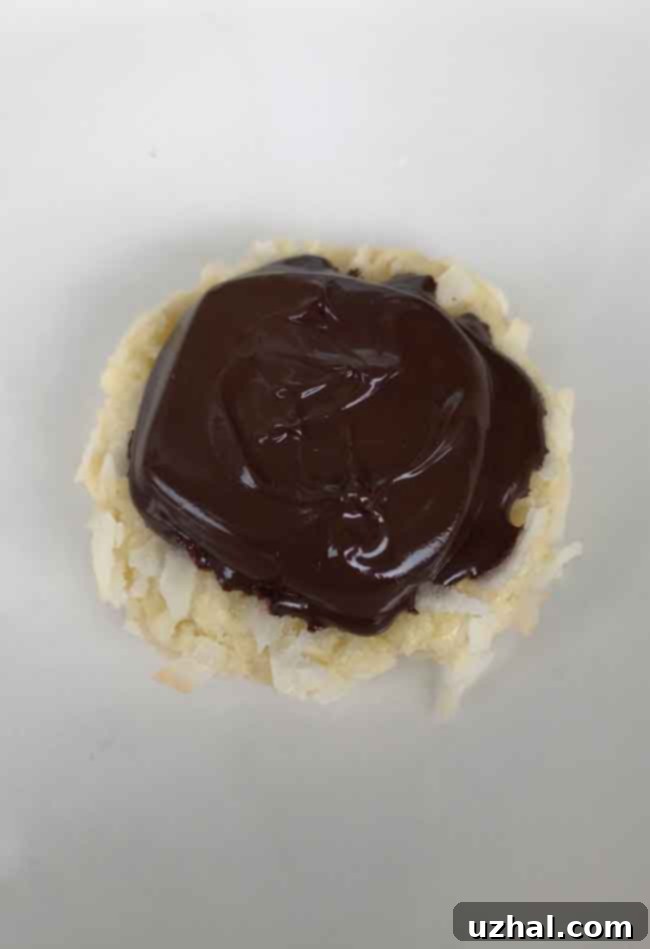 A close-up of a Hershey's Kisses Coconut Macaroon, showing a perfectly melted dark chocolate center, possibly a Dove chocolate.
