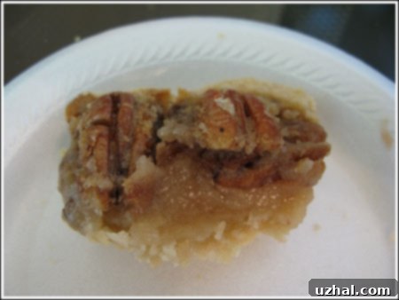 A large slice of egg-free pecan pie served on a white plate, showcasing the thick, rich filling.